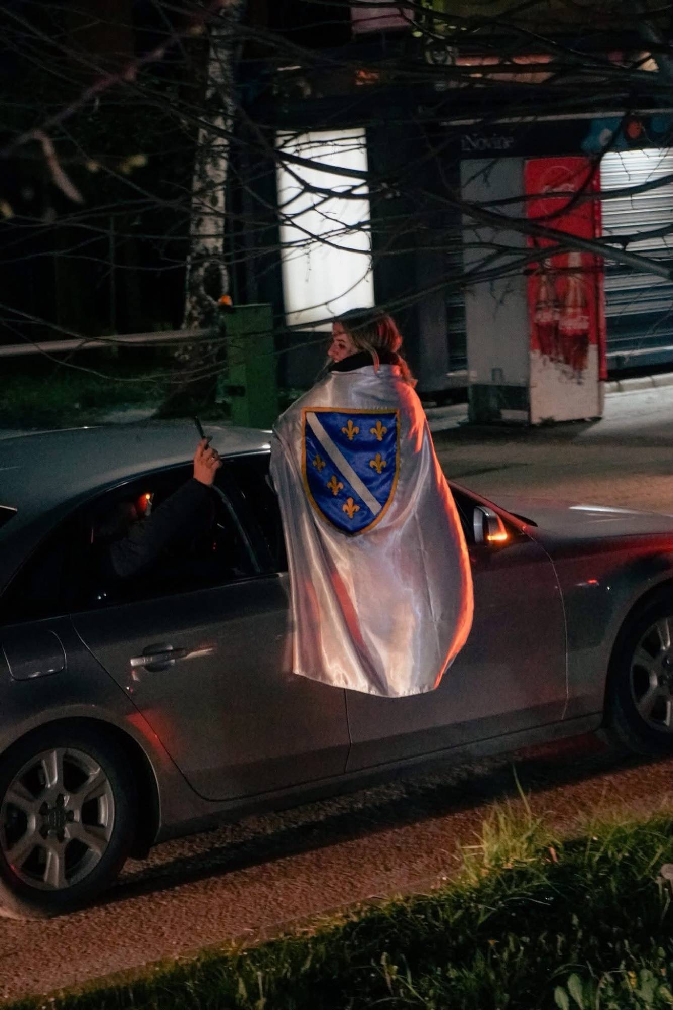 Djevojka sa zastavom na prozoru automobila u noćnom kadru